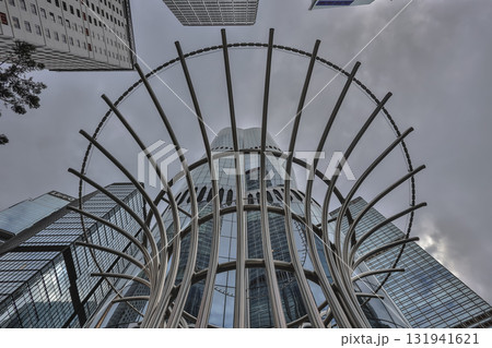 Oct 4 2025 Sleek Glass Skyscraper Behind Spiral Stainless Steel Sculpture 131941621