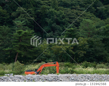 夏の山の森の風景と河川で工事する重機の様子	 131942388
