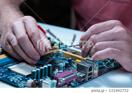 A master repairs a motherboard from a computer 131942752