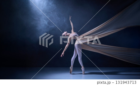 Ballet dancer wrapped in stretched fabric performing balanced backbend 131943713