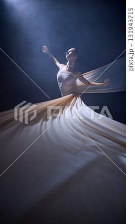 Ballet dancer in motion wrapped in fabric performing upward stretch 131943715