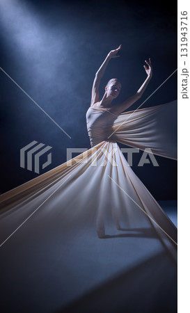 Ballet performer wrapped in fabric extending arms under spotlight 131943716