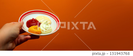 A captivating banner image featuring a hand holding a white plate with samples of various dipping sauces, ketchup, mustard, mayonnaise, garlic sauce. Copy space A captivating banner image featuring a hand holding a white plate with samples of various dipping sauces, ketchup, mustard, mayonnaise, garlic sauce. Copy space 131943768
