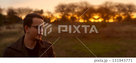 portrait of a young man 20s wearing eyeglasses, set outside agai 131943771
