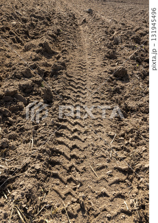 traces of a tractor on a field during tillage, soil in a field with traces of passing heavy agricultural machinery after tillage traces of a tractor on a field during tillage, soil in a field with traces of passing heavy agricultural machinery after tillage 131945496