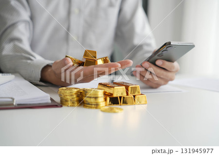Gold Trading Businessman invest in trading gold, calculating profit price of gold in stock market when price rising rapidly, using phone monitoring gold price in stock market. Gold Trading Businessman invest in trading gold, calculating profit price of gold in stock market when price rising rapidly, using phone monitoring gold price in stock market. 131945977
