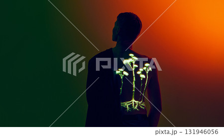 Man with neon botanical projection on back in orange and green gradient lighting Man with neon botanical projection on back in orange and green gradient lighting 131946056