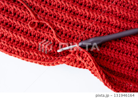 Close up of red crochet fabric with hook for knitting enthusiasts 131946164