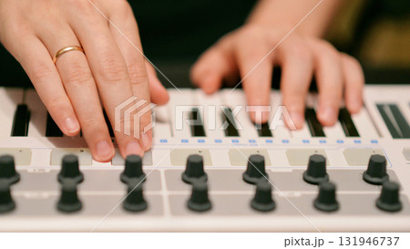 A Man Playing Synthesizer Keyboard MIDI Controller. Hands close up. Electronic Music Production concept. A Man Playing Synthesizer Keyboard MIDI Controller. Hands close up. Electronic Music Production concept. 131946737