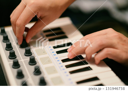 A Man Playing Synthesizer Keyboard MIDI Controller. Hands close up. Electronic Music Production concept. A Man Playing Synthesizer Keyboard MIDI Controller. Hands close up. Electronic Music Production concept. 131946738