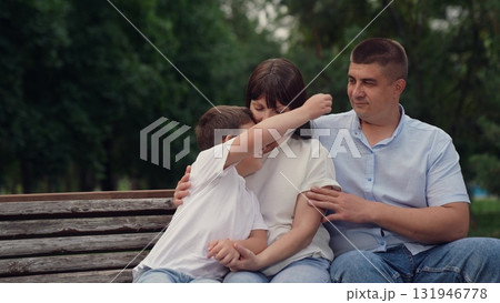 man woman with child kid bench hugging, child hugging mother outdoors, man hugging relatives, mother parent hugging child kid son boy, woman man son kid outdoors, family walk nature, concept happy 131946778