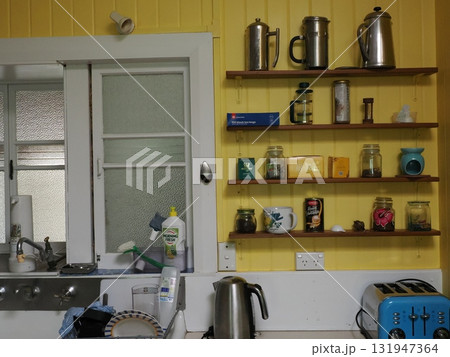 ケアンズの朝–黄色い壁に並ぶ暮らしの道具 ダイニング、民泊、キッチン、黄色、壁、棚、窓、光、影、構図 131947364