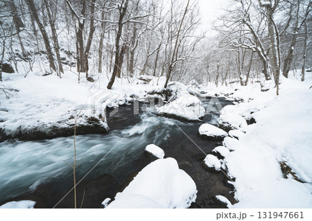 雪に覆われた冬の森と渓流の風景 131947661