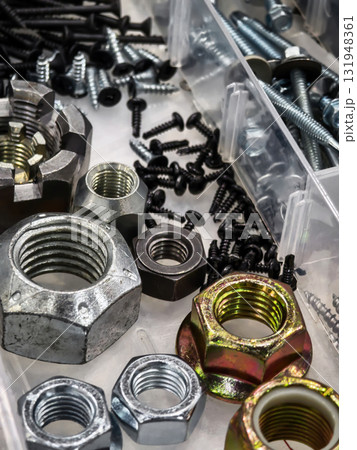 Variety of nuts and bolts organized in storage containers on a workspace Variety of nuts and bolts organized in storage containers on a workspace 131948361