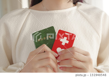 障害者手帳を胸元に持つ女性 131948548