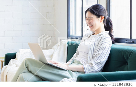 ソファーに座ってパソコンを使う女性 ソファーに座ってパソコンを使う女性 131948936
