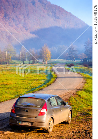 perechyn, ukraine - 10 nov 2020: car near asphalt road in autumn. trip through countryside mountain landscape of ukraine with morning fog. hyundai hatchback on the roadside near forest and field perechyn, ukraine - 10 nov 2020: car near asphalt road in autumn. trip through countryside mountain landscape of ukraine with morning fog. hyundai hatchback on the roadside near forest and field 131949176