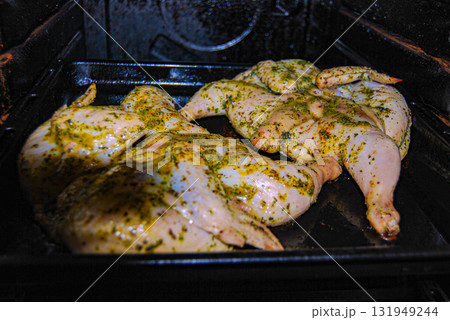 Chicken roasting in oven. Two tobacco chickens on a baking sheet in the oven. 131949244