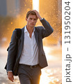 Exhausted businessman wiping sweat off his brow on a hot sunny day in the city. 131950204