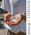 Hands Holding a Melting Ice Cube as a Symbol of Global Warming. 131950206