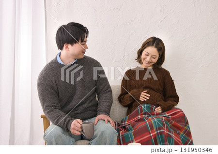 ソファに座ってくつろぐ若い夫婦　妊婦さん 131950346