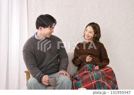ソファに座ってくつろぐ若い夫婦　妊婦さん 131950347