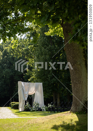 Elegant wedding ceremony venue with draped fabric and floral decoration 131950809