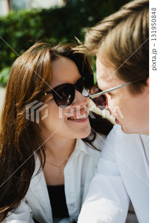Young loving married couple sharing a joyful moment outdoors in bright sunlight with greenery Young loving married couple sharing a joyful moment outdoors in bright sunlight with greenery 131950848