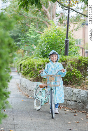 雨の日にレインコートを着て自転車に乗る子供 131951180