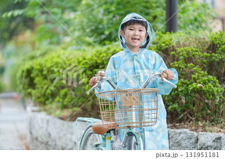 雨の日にレインコートを着て自転車に乗る子供 131951181