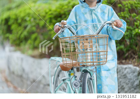 雨の日にレインコートを着て自転車に乗る子供 131951182