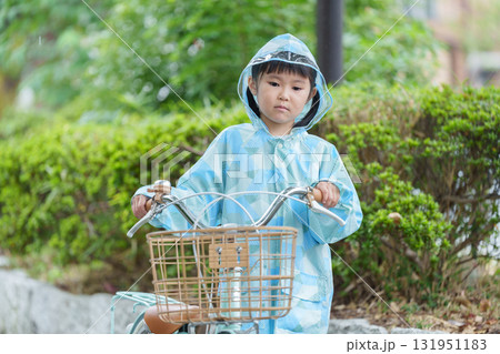 雨の日にレインコートを着て自転車に乗る子供 131951183