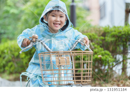 雨の日にレインコートを着て自転車に乗る子供 131951184