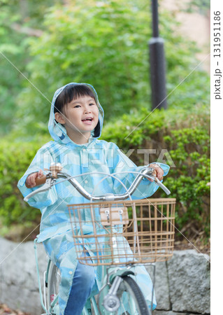 雨の日にレインコートを着て自転車に乗る子供 131951186