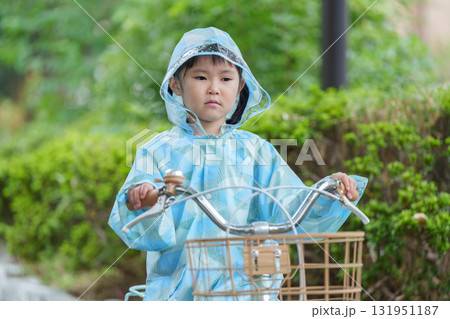 雨の日にレインコートを着て自転車に乗る子供 131951187