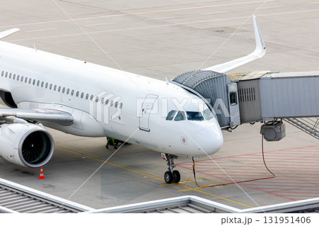 modern regional passenger airplane connected to jet bridge airport terminal boarding ground operations. Modern jet stands on tarmac ready for next flight, symbolizing global travel and transportation modern regional passenger airplane connected to jet bridge airport terminal boarding ground operations. Modern jet stands on tarmac ready for next flight, symbolizing global travel and transportation 131951406