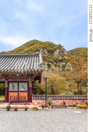 The entrance to Jangansa Temple in Gijang, Busan, South Korea, with autumnal scenery of mountains and persimmon trees. Blue sky. 131952112