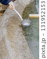Close-up of a child's hand receiving clean, cool, flowing medicinal water from a ladle. 131952153