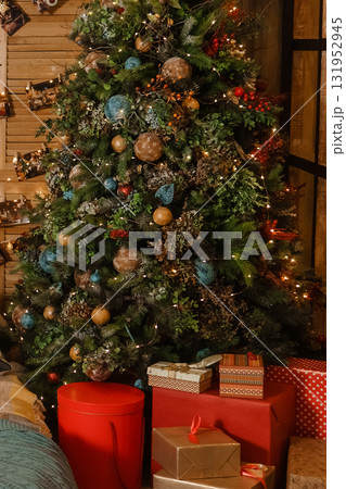 Decorated Christmas tree with lights and ornaments. Festive holiday interior decoration for celebration greeting card. Decorated Christmas tree with lights and ornaments. Festive holiday interior decoration for celebration greeting card. 131952945