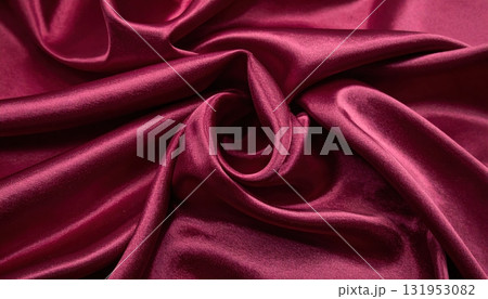 Luxury red silk and satin fabric with a smooth, shiny texture creates an elegant backdrop with soft waves and drapery 131953082