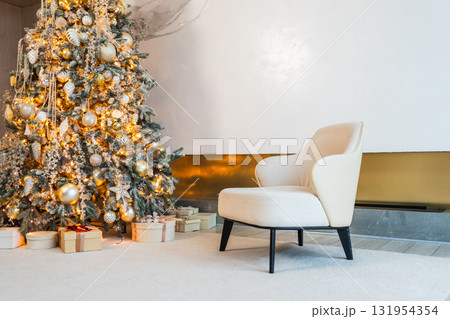 Classical Christmas decorated interior living room. Modern classic style interior design apartment with cozy chair and Christmas tree with white golden ornament decorations. Christmas eve at home Classical Christmas decorated interior living room. Modern classic style interior design apartment with cozy chair and Christmas tree with white golden ornament decorations. Christmas eve at home 131954354