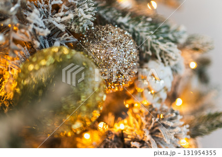 Merry Christmas Xmas happy holidays. Golden silver ornament decoration ball, defocused garland lights on classic decorated Christmas tree. Christmas tree with frosty ornaments. Christmas eve at home 131954355