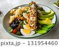 Roasted salmon steak with various vegetabls, avocado, green pea, olove, kidney beans, white beans in white ceramic plate. 131954460