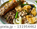 Homemade delicious mixed cereals salad with avocado, green vegetables, olive  and roasted salmon steak in white ceramic plate. 131954462