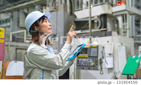 タブレットを持って工場機械を点検する女性作業員 タブレットを持って工場機械を点検する女性作業員 131954550