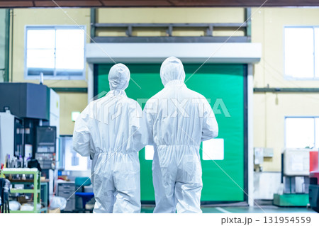 防護服を着て工場を歩く男女作業員 131954559