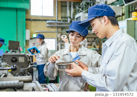 工場で工作機械を操作する作業員グループ 131954572