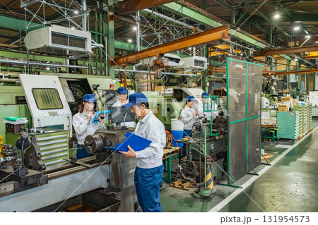 工場で工作機械を操作する作業員グループ 131954573