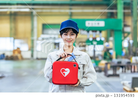 工場でAEDを持つ女性作業員 131954593