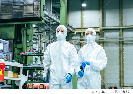 工場を歩く防護服を着た男女作業員 工場を歩く防護服を着た男女作業員 131954687